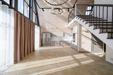 Bright, modern interior featuring a high-ceilinged room with large windows, tile flooring, and a...