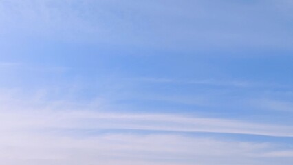 Beautiful scene of soft fluffy white clouds floating in a clear blue sky on a bright summer day, creating a calm and serene atmosphere. Ideal for nature, travel, relaxation, weather themed designs.