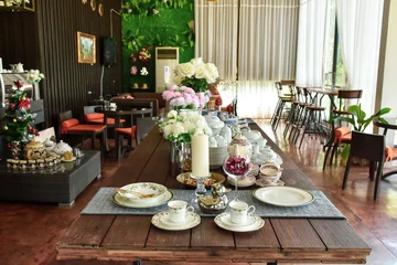 Fotobehang Eetkamer wedding reception at the restaurant. still life with flowers and teapot. Wedding decor. Flowers in the restaurant, table setting  © Suphattra