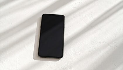 Modern phone on white surface with shadows