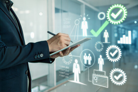 Businessman using tablet with glowing digital interface and business analytics icons