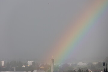 A rainbow is seen in the sky above a city