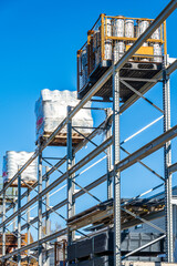 Bright and organized construction supplies stored on shelves under clear blue sky at a busy...