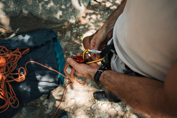 man getting the rope ready to go outdoor climbing