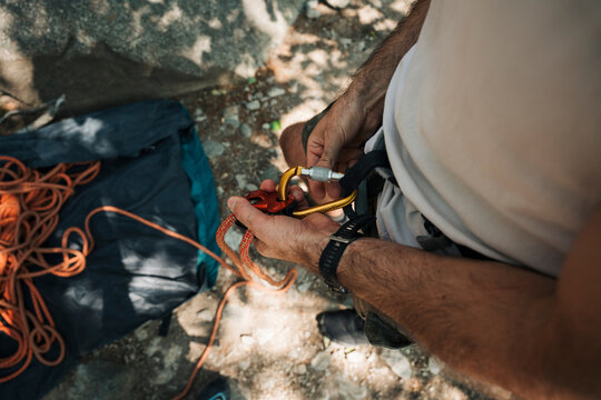 man getting the rope ready to go outdoor climbing