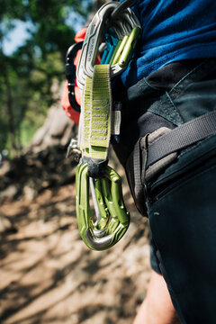 quick draws on a climbing harness on a man ready to climb outdoors