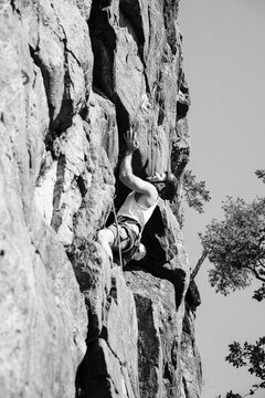 man rock climbing outdoors in Sweden on a sunny day