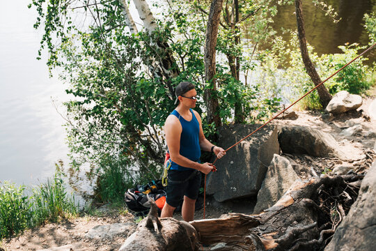 man wearing climbing glasses whilst belaying his friend