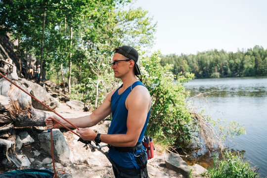 man wearing climbing glasses whilst belaying his friend