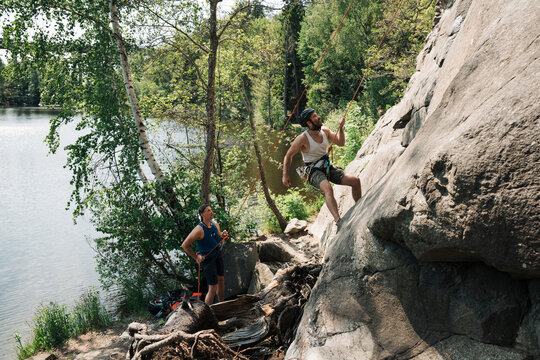 two friends outdoor climbing next to the sea in Sweden