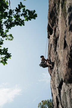 man climbing up an outdoor rock face in Sweden