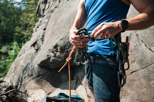 man clipping quick draws to carabiner's whilst outdoor climbing