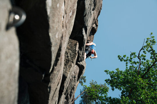 man high up on a rock face climbing outdoors in Sweden