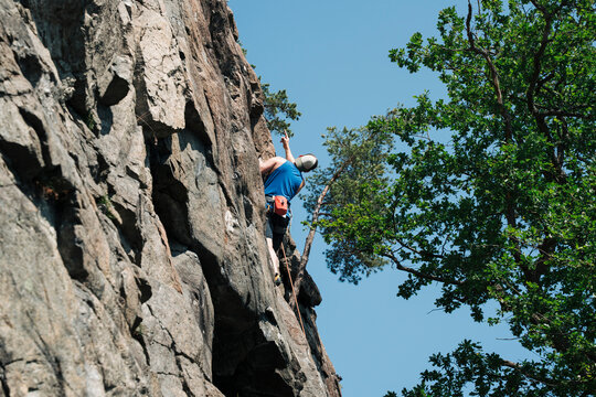 man planning his route whilst up a rock climbing outdoors