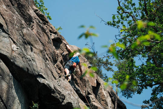 man climbing up a rock face in Stockholm Sweden