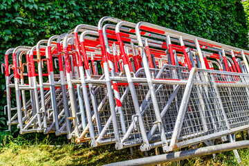 Metal barriers stacked on a city street near an event location in bright sunlight during daytime...