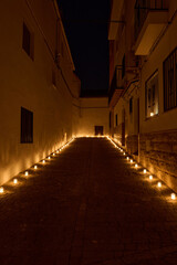 Tranquil Night Alleyway Illuminated by Aligned Candle Lights