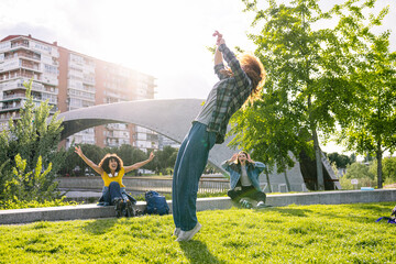 Young woman performing an impressive backflip in a vibrant park, surrounded by friends cheering...