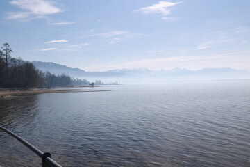 A calm lake with a few trees in the background
