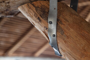Metal bracket with large nails hold wooden logs