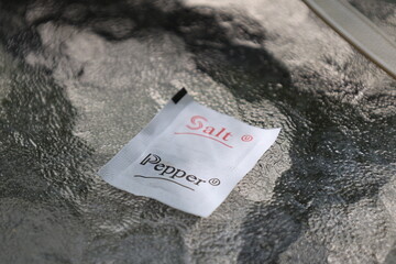 Sign salt and pepper pack on clear glass background