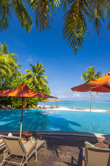 Stunning sunny tropical resort in Maldives swimming pool, palm leaves, loungers umbrella under blue...