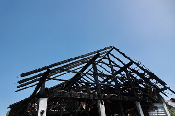 A house with a black roof and a blue sky in the background