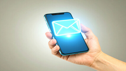 Hand holding smartphone with glowing email icon