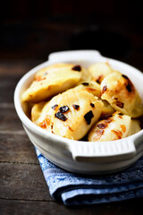 Dumplings with potato and cottage cheese stuffing (pierogi). Wooden background. Copy space.	