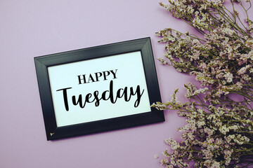 Happy Tuesday text with flowers bouquet decoration on purple background