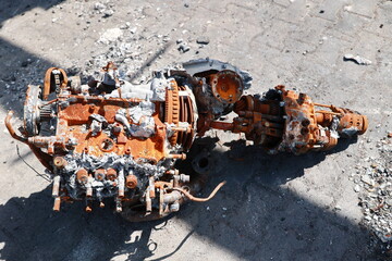 A rusted engine is on the ground, with a lot of debris around it