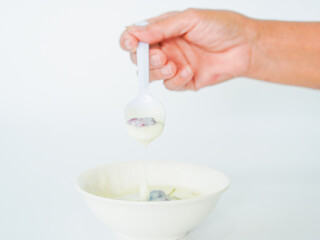 Close up people hand eating yogurt cream sweet fruit at home in morning. Breakfast homemade...