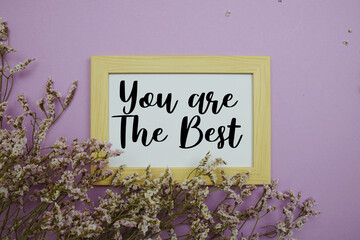 You are The Best text with flowers bouquet decoration on purple background