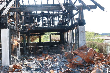 A burned down building with a lot of debris and a lot of smoke