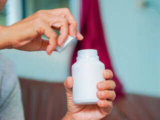 Close up hand holding medicine bottle for concept home care, patients health care and wellness...