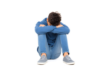 Lonely boy sitting on floor, looking down with sad posture. Concept of bullying, isolation, or emotional struggle.