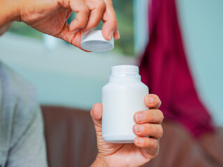 Close up hand holding medicine bottle for concept home care, treatment, patients and wellness...
