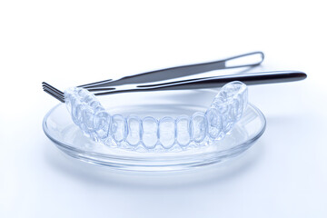 Dental night guard with clear material and case. Useful for visuals on oral care, sleep protection, or orthodontics.