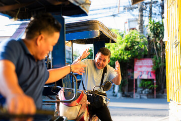 Asian tricycle driver raises hands mid-argument in frustration, expressing annoyance and...