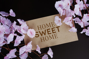 Home sweet home text message with flower decoration on black background