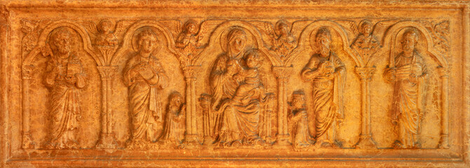 PIACENZA, ITALY - MAY 19, 2025: The marble relief of Madonna among the sanits as the tomb stone of family Scotti - Basilica di San Giovanni in Canale by unknown artist. 