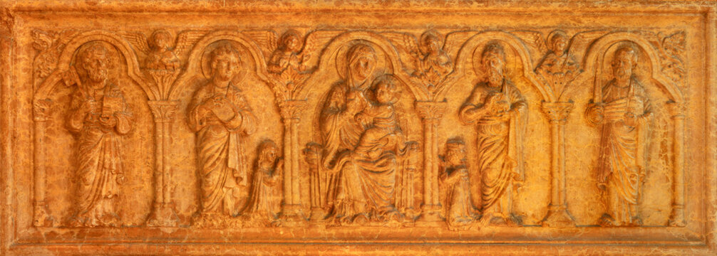 PIACENZA, ITALY - MAY 19, 2025: The marble relief of Madonna among the sanits as the tomb stone of family Scotti - Basilica di San Giovanni in Canale by unknown artist. 