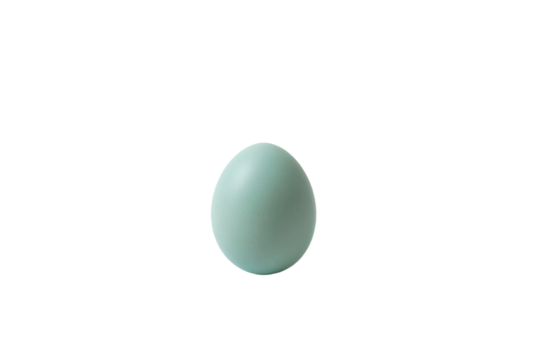 a green egg is sitting on a white surface