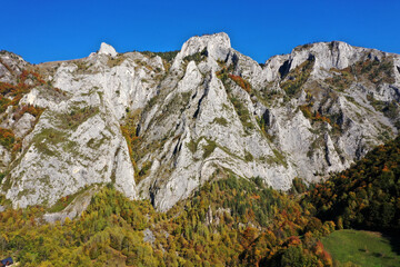 Aerial view of rocky limestone mountains and autumn forest