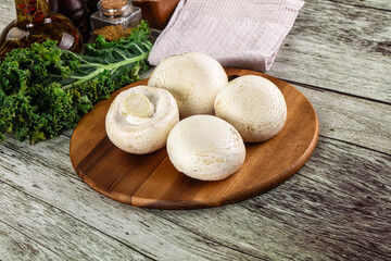 White champignon mushrooms heap over board