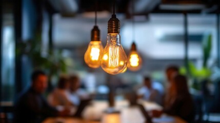 A warm, glowing light bulb hangs prominently in a modern office setting where blurred people collaborate in the background.