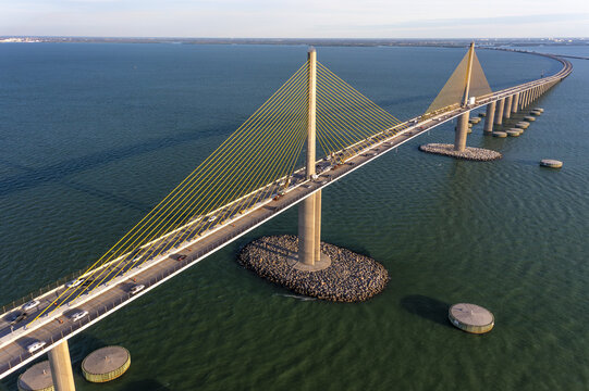Aerial view of the expansive Sunshine Skyway Bridge stretching over the shimmering turquoise waters of Tampa Bay, Florida, connecting land and sky., St. Petersburg, Florida, United States.