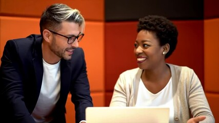 Two colleagues are engaged in a productive discussion in a modern workspace. They appear cheerful as they review a project on a laptop, showcasing teamwork and creativity - Powered by Adobe