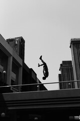 Black and white photo of a man performing a parkour trick. Extreme sports photo.