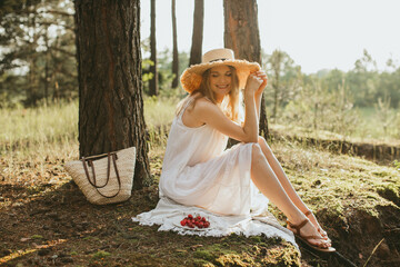 Woman enjoying relaxing picnic in sunny forest